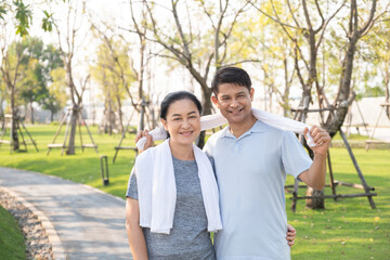 Fototapeta premium A happy retired senior Asian couple smiling and looking at the camera look like very happy in the park.