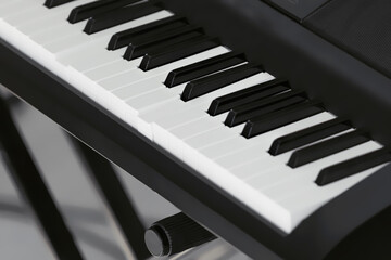 Selective focus of a part of a black-and-white synthesizer with keys, two of which have sunk.