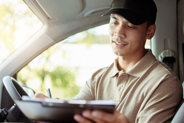 Making sure that all of my info is correct. Shot of a delivery man checking the paperwork for his...