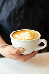 barista holding cup of coffee