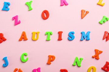 Flat lay composition with word Autism on pink background