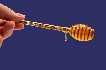 fresh honey dripping from a spoon on a dark background. organic vitamin health food