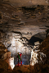 Man is searching a way inside the cave; speleology