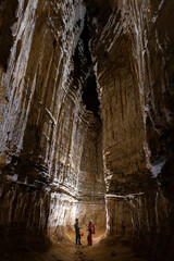 Huge gallery inside the cave with people cavers -  speleology