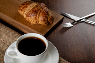 Croissant with a cup of full coffee,directly above