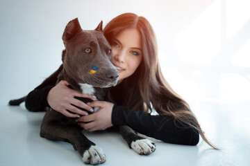 young ukrainian beautiful female play with staffordshire terrier dog at hoe
