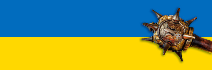 mace with emblem of Ukraine trident on blue and yellow national Flag of Ukraine. War concept....