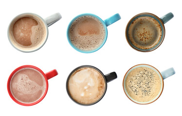 Set of mugs with tasty hot drinks on white background, top view