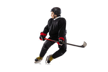 Dynamic portrait of kid, hockey player in black sportswear and helmet training isolated over white studio background