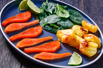 salmon slices with spinach leaves, roast potatoes
