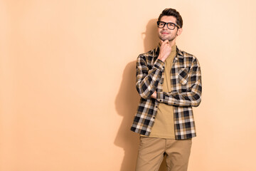 Portrait of attractive cheerful dreamy guy making decision copy blank space isolated over beige pastel color background