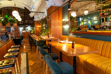 Fototapeta na wymiar Interior of modern loft style restaurant with fresh flowers and mirror