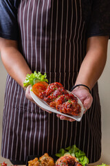 Person holding a plate of Korean fried rice, ready to serve