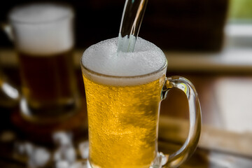 fresh beer with bubbles in a glass mug over dark wooden background in a pub or bar. High quality photo