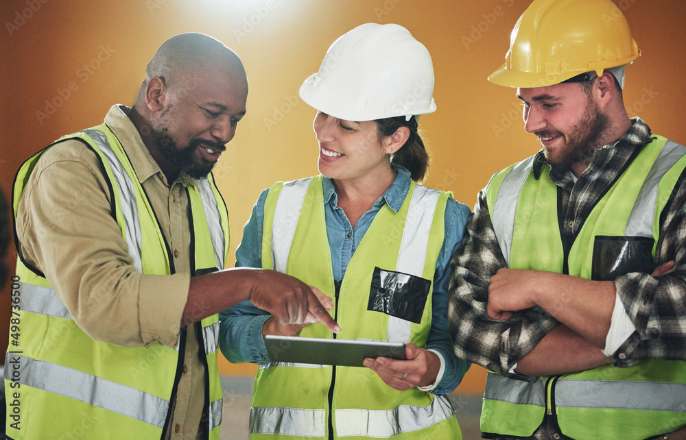 Poster Using modern tech for a modern finish. Shot of a group of builders using a digital tablet while working at a construction site.