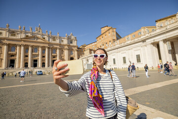 Young woman walks on saint Peter's square in Vatican. Concept of visiting religious places and travel Italy