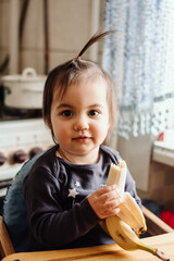 Cute baby eating banana. Cute little girl eating fruit. Healthy snack, food