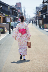 観光地の古い街並みで散歩している着物姿の女性
