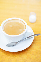 木製のテーブルの上のコーヒーとミルクピッチャー