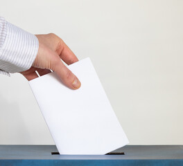 hand putting her vote in a ballot