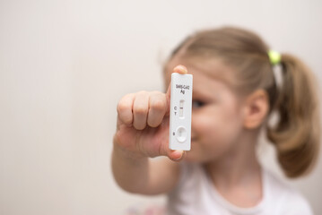 Child holding a negative express test for covid, space for text