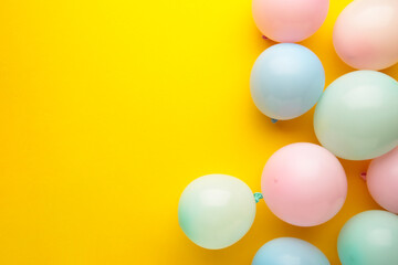Birthday background with colorful balloons on yellow background, top view