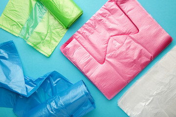 A lot of colored plastic bags rolls on a blue background.