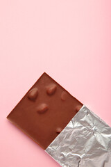 Chocolate wrapped in foil, clipping path on purple background. Vertical photo.
