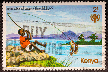 Kenya - circa 1979: a postage stamp from Kenya , showing a child on a beach with sea and mountains...