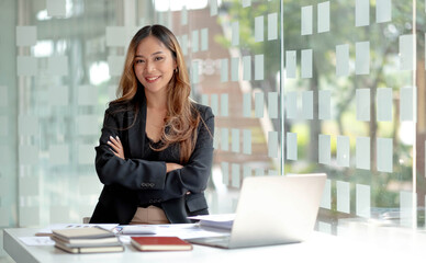 Image of a charming young Asian businesswoman standing at the office. Looking camera.