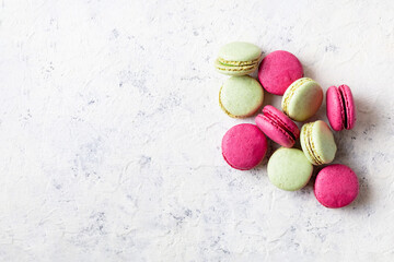 Pink and green macaroons on white background. Traditional French sweet dessert.