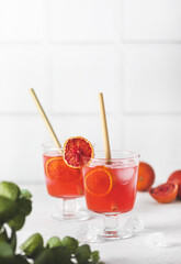 Red citrus photo of orange tangerine gin alcohol cocktail food photo on a table. Tasty citrus beverage banner copy space.