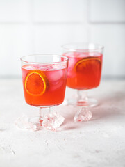 Red citrus photo of orange tangerine gin alcohol cocktail food photo on a table. Tasty citrus beverage banner copy space.