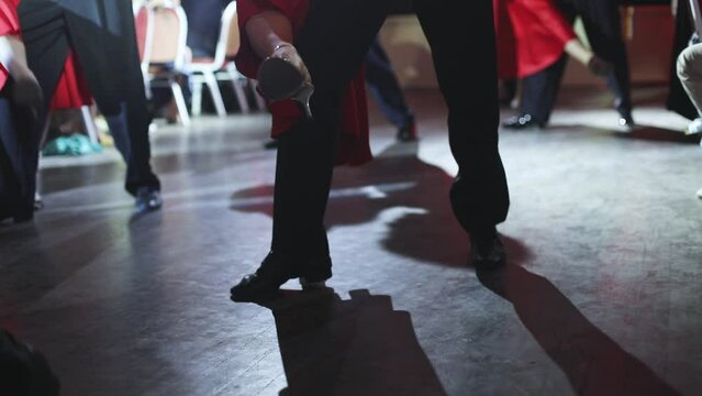 Dancing shoes of young couple, Couples dancing traditional latin argentinian dance milonga in the ballroom, tango salsa bachata kizomba lesson, dance festival, wooden floor, close up view of shoes