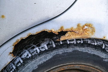 Rust on the door and fender of the car. Consequences of salt, snow, reagents in the north.