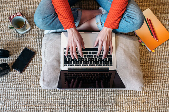 Crop female freelancer working on floor