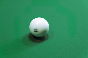 White billiard ball with roman numeral two n the green billiard table. Close-up.