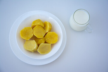 Powdered vegan milk. Potato milk close-up. Boiled potatoes in a white plate. Selective focus. Top view.