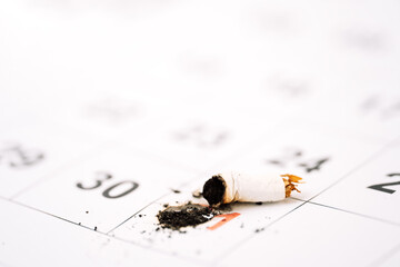 Extinguished cigarette about 31 days in the calendar closeup.