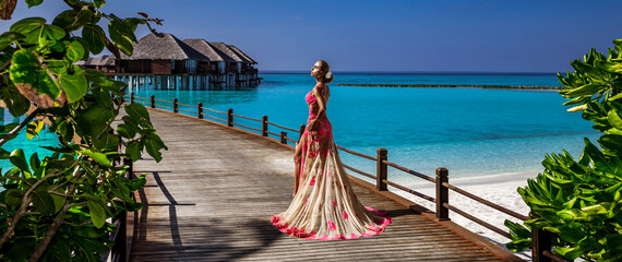 Luxury fashion. Elegant fashion model is posing outdoor. Stylish female model in long gown dress on...