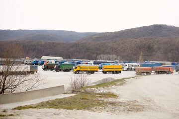 Panoramic view with a rest area of truck parking with trailers parked in a row next to the road.
