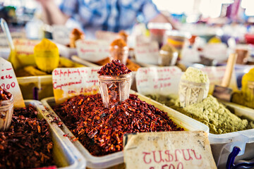 Heaps of spices on the market in Yerevan, Armenia. Tashir traditional market in Armenia. TRANSLATION of writing in Russian and Armenian: Pepper, paprika, coriander, zira, suneli, Armenia
