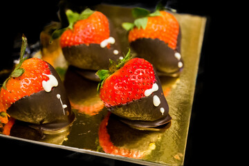 Top view of Strawberries chocolate coating on the golden pad, focus selective