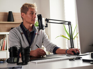 Graphic designer/photographer working in home office and record a video blog