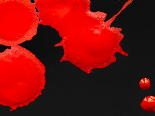 Fototapeta na wymiar Blobs of red paint on a black background.