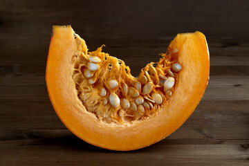 Fresh organic pumpkin slice on dark background.