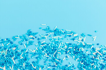Sugar sprinkles in shape of star moon sticks on light blue background. Spase for text. Easter concept.