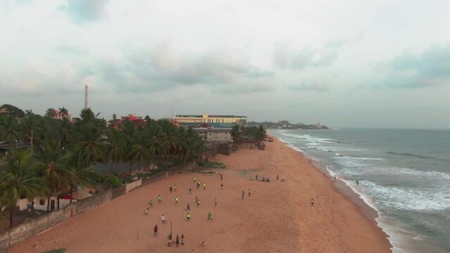 people walking and playing football on a beach in Monrovia, Liberia in West Africa