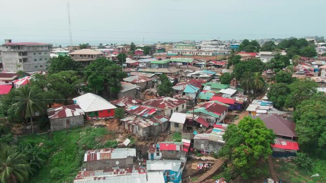 Aerial drone shot of a poor slum area in Monrovia, Liberia with the Atlantic Coast of West Africa background