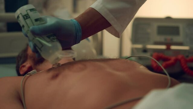 Doctor hands defibrillating patient in hospital emergency facility close up. 